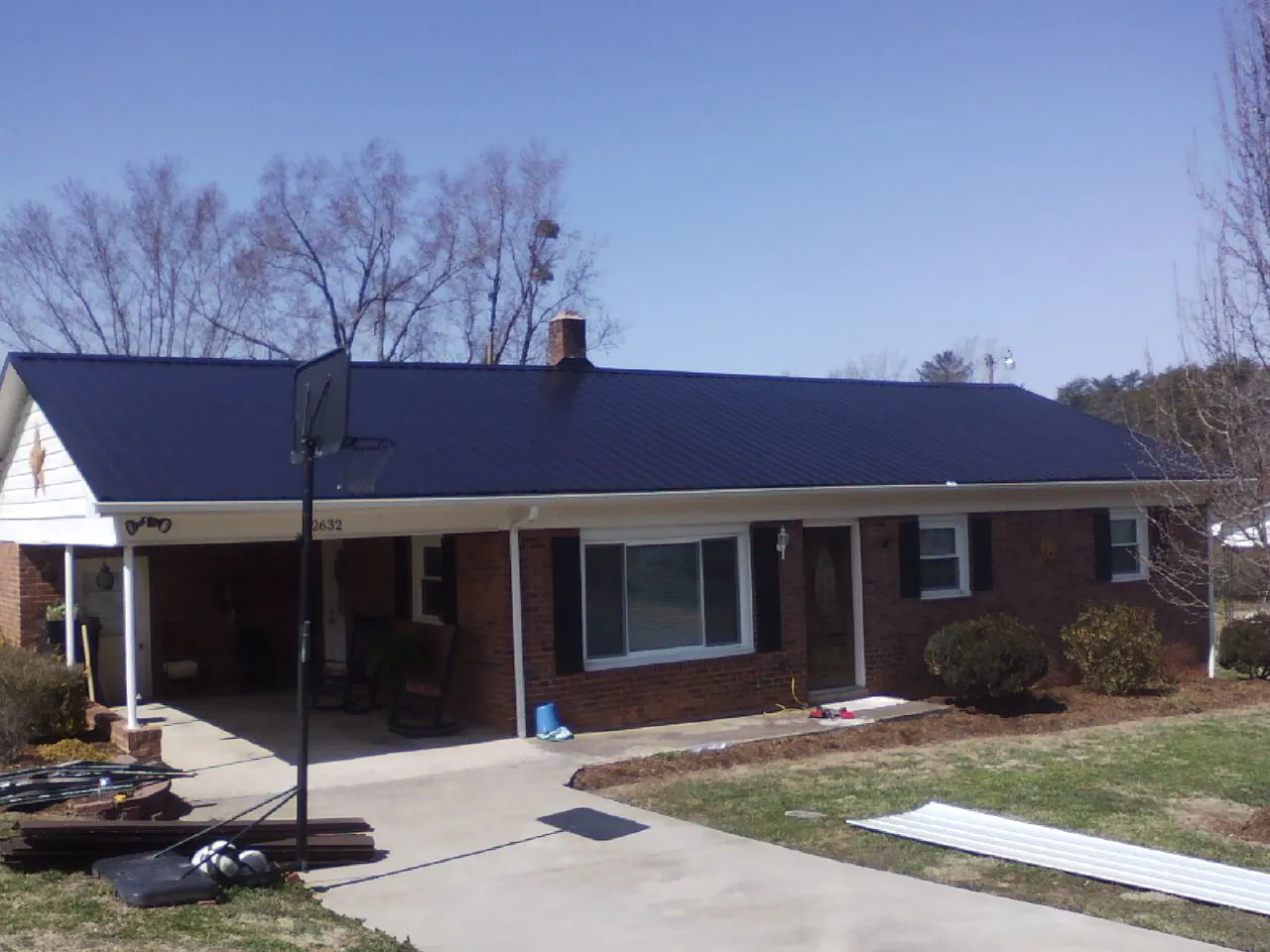 Finished dark blue metal roof on a brick ranch with a carport in Denmark